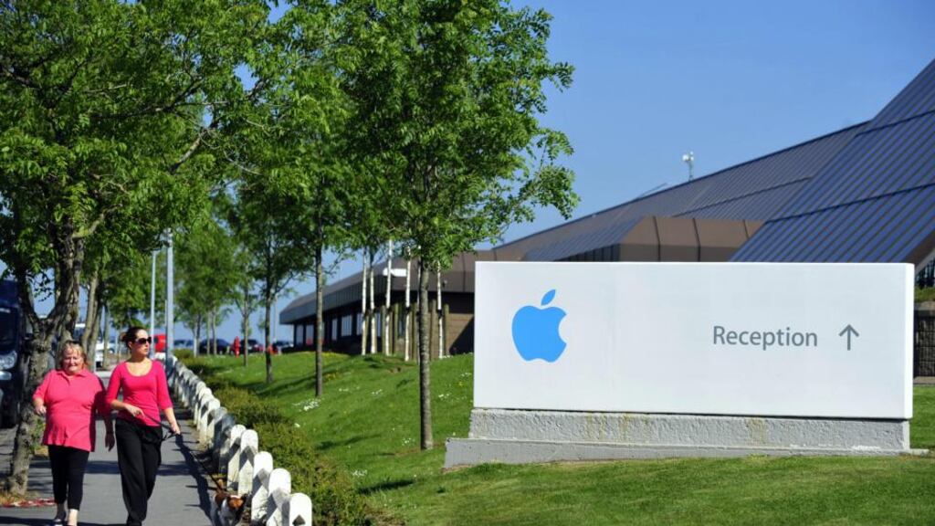 Pedestrians walk with a dog near Apple’s campus in Cork. The company is the largest private employer in Cork, where it has around 4,000 people employed in roles, including supply chain and risk management operations.