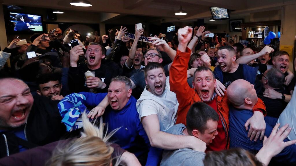 Leicester City fans celebrate after Chelsea equalised against Tottenham, handing their club the Premier League title. Photo: Eddie Keogh/Reuters