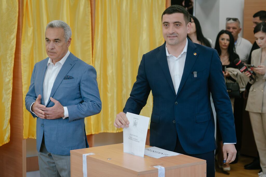 Presidential candidate George Simion (right) prepares to cast his vote on Sunday next to former presidential candidate Calin Georgescu in the first round of Romania's presidential election. Photograph: Andrei Pungovschi/Getty Images