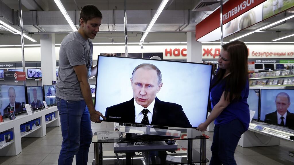 Vladimir Putin’s state-of-the-nation address on television in an electronics shop in Moscow. Photograph: Yurk Kochetkov/EPA