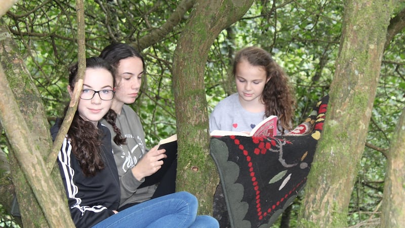 Quinn’s daughters Aine, Lucy and Olivia reading in a tree-house rug