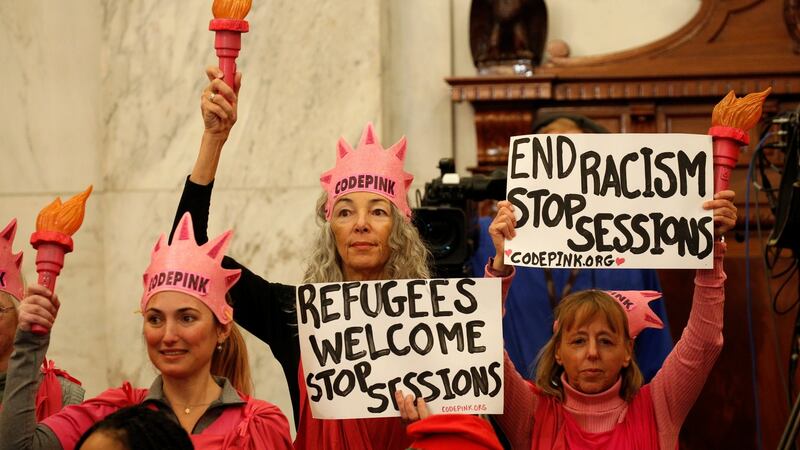 Protesters hold signs at the Senate Judiciary Committee confirmation hearing for Senator Jeff Sessions to become US attorney general, on Capitol Hill in Washington. Photograph: Kevin Lamarque/Reuters