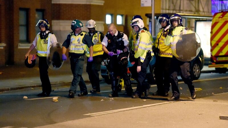 Police officers hold a person on Romford Road in Forest Gate, east London, during clashes on Sunday night. Photograph: PA