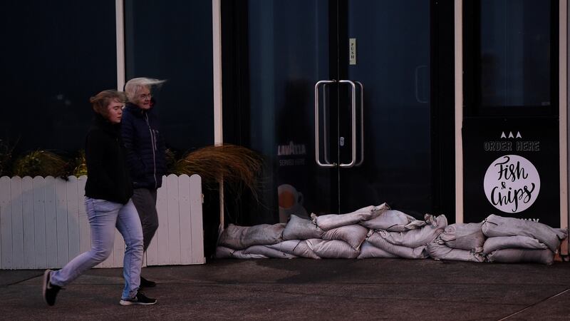 People walk past a sandbagged chip shop during Storm Ophelia in Galway, Ireland. Photograph: REUTERS/Clodagh Kilcoyne