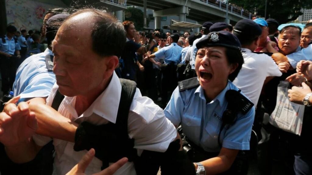 A policewoman stops an anti-Occupy protester from breaking a police cordon to charging at pro-democracy protesters in Hong Kong yesterday. Photograph: Reuters/Bobby Yip