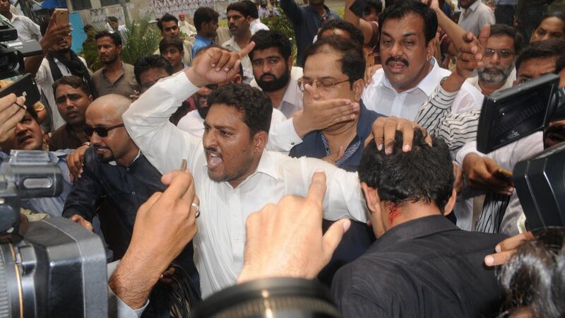 Supporters of opposition political party Pakistan Tehrik-e-Insaf display a injury on a man who was wounded during a clash with supporters of Nawaz Sharif. Photograph: Faisal Kareem/EPA