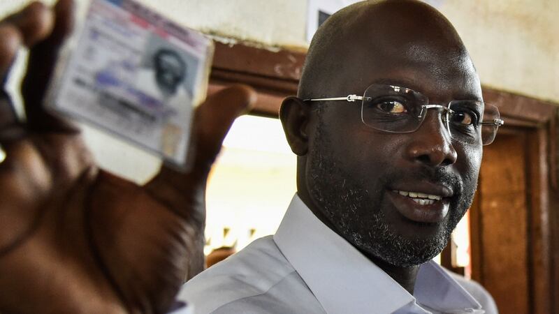 George Weah, former international Liberian football star and now presidential candidate, shows his voting card prior to casting his vote in Liberia’s presidential and legislative elections at a polling station in Monrovia on October 10th, 2017. Photograph: Issouf Sanogo/AFP/Getty Images