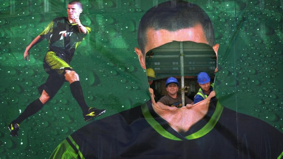 Builders in Dublin city centre peer through the hole where Roy Keane’s face had been cut out of a giant advertising hoarding after it was announced that the player would be returning from the World Cup. Photograph: Bryan O’Brien