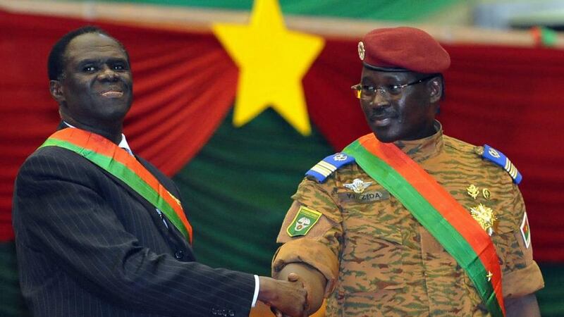 A picture from  November 21st, 2014, taken in the capital of Burkina Faso, Ouagadougou, shows then interim president  Michel Kafando (left) shaking hands with prime minister Lt Col Isaac Zida during Mr Kafando’s inauguration ceremony. File photograph: Sia Kambou/AFP/Getty Images