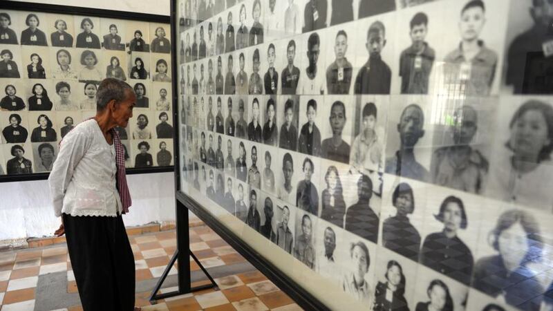 A Cambodian woman looks at photos of victims of the Khmer Rouge at the Tuol Sleng museum in Phnom Penh. Photograph: Tang Chhin Sothy/AFP/Getty Images