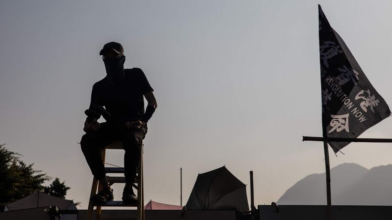 A protester sits at a makeshift lookout on a bridge at the Chinese University of Hong Kong. Photograph: Dale De La Rey/ AFP