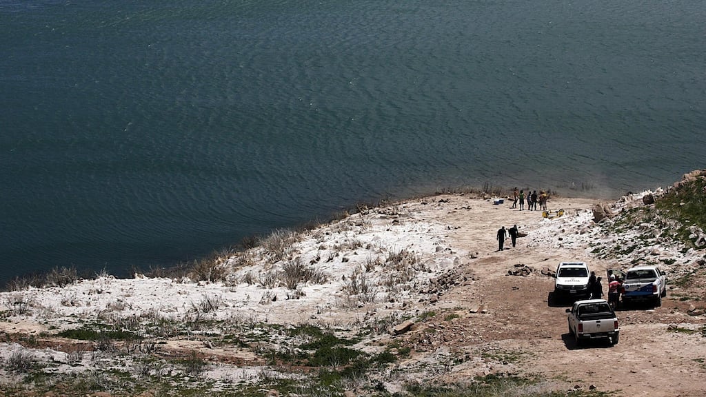 Rescue crews on the banks of an artificial lake in the Mendoza river where a helicopter crashed. Photograph: AFP