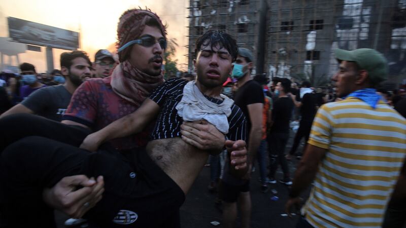A wounded Iraqi protester is carried by a comrade during a demonstration against Adel Abdul Mahdi’s year-old government. Photograph: Getty Images