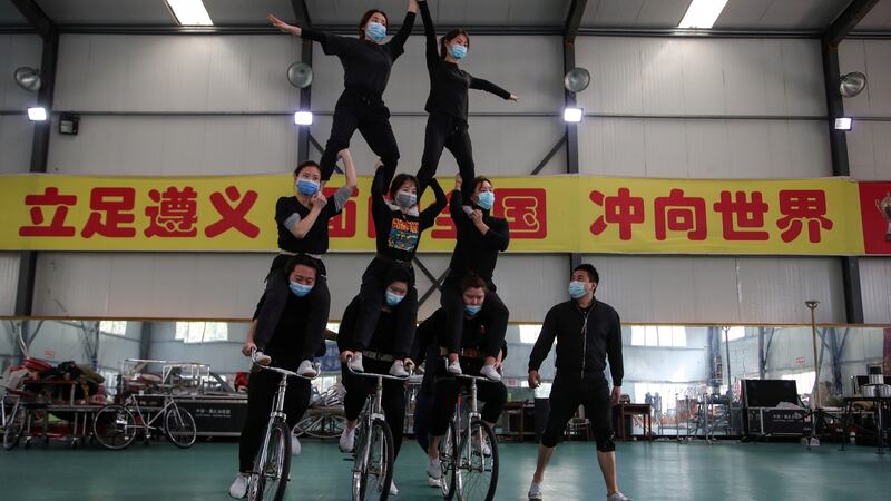 Members of an acrobatic team wearing face masks to prevent the spread of coronavirus disease  train for a performance in the United States, at a sports stadium in Zunyi, Guizhou province on Saturday. Photograph: Reuters