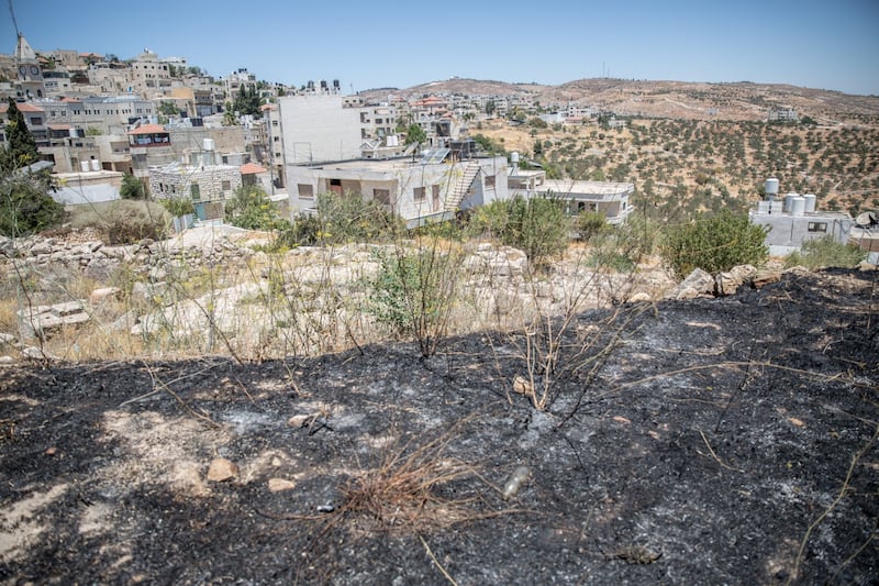 Charred ground set on fire by settlers in Taybeh, close to the Church of Saint George. Photograph: Sally Hayden