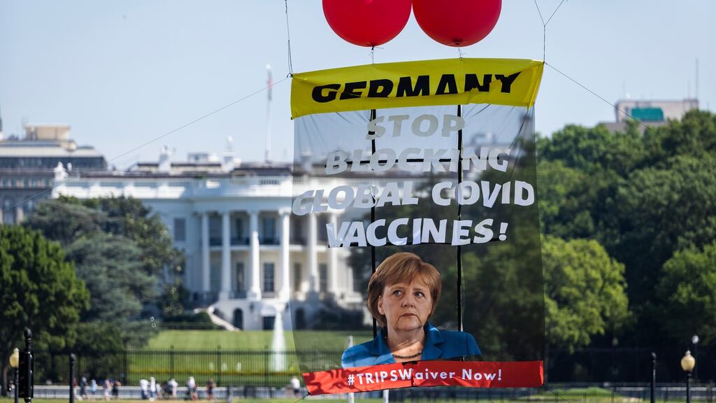 ShutDownDC activists float a banner with helium balloons calling on German chancellor Angela Merkel to endorse the waiver for intellectual property rights around the Covid-19 vaccine outside the White House in Washington, DC. Photograph: Jim Lo Scalzo/EPA