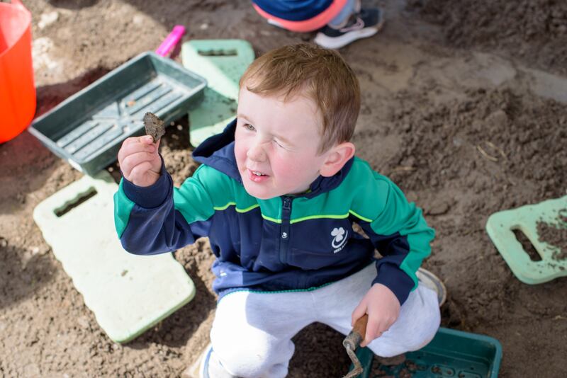 A budding archaeologist examines his find