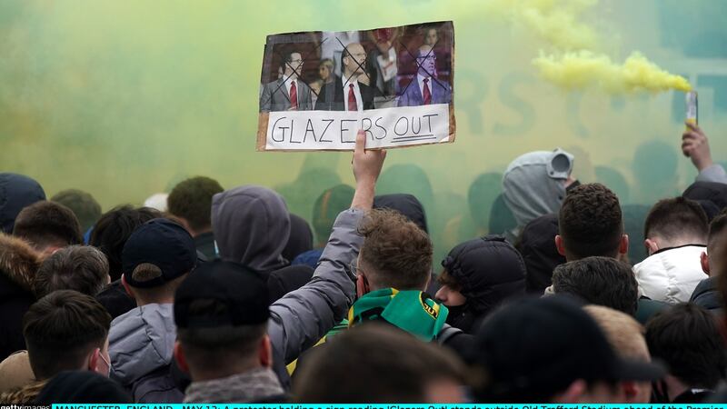 A protester holds a sign reading ‘Glazers Out’. Photo: Christopher Furlong/Getty Images