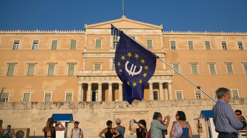 A protestor holds a European Union flag with a euro symbol at Syntagma Square in Athens. Photograph: Bloomberg