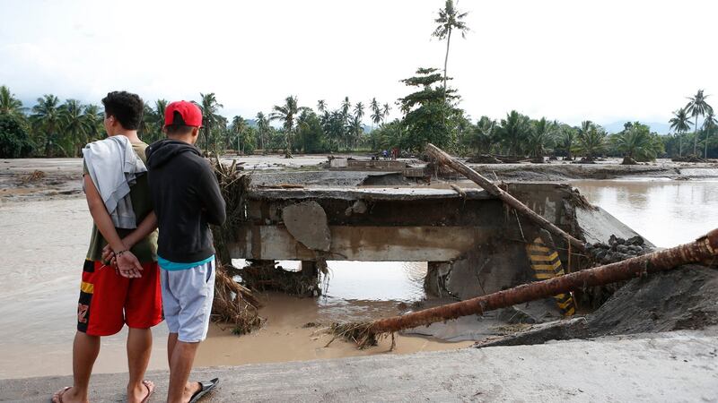 Filipino villagers look at a damaged bridge in the flood hit town of Salvador in Lanao del Norte province on Saturday. Photograph: Jeoffrey Maitem/EPA.
