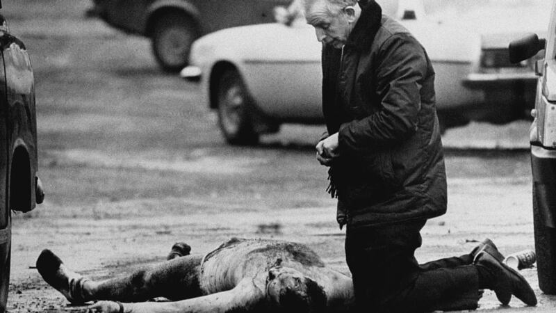 Fr Alec Reid praying over the body of one of the murdered soldiers in Belfast, March 1988. Photograph: Trevor McBride