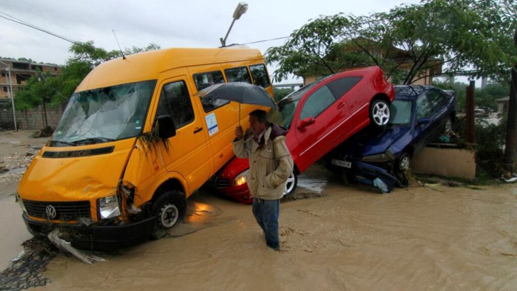 A man walks past damaged vehicles following heavy flooding in the city of Varna, north-eastern Bulgaria. Photograph: Reuters