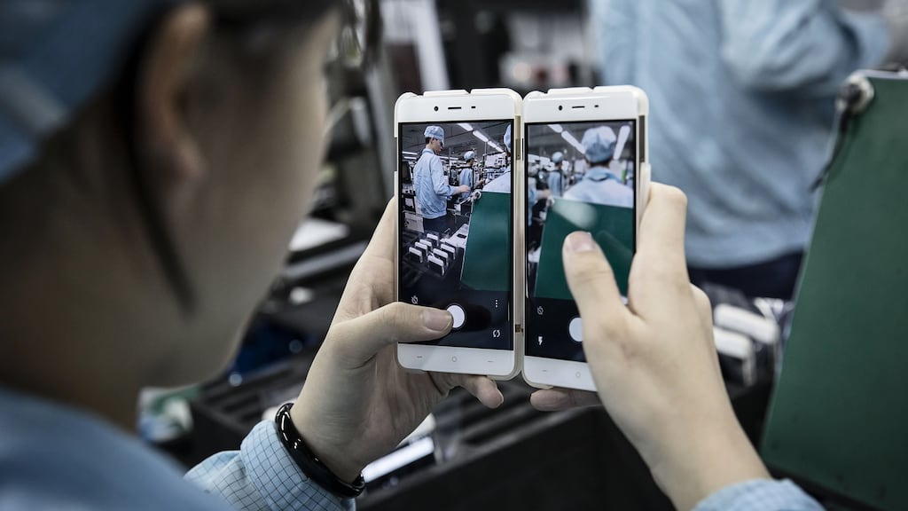 An employee tests the cameras of OnePlus X smartphones at the OnePlus manufacturing facility in Dongguan, China. Photographer: Qilai Shen/Bloomberg