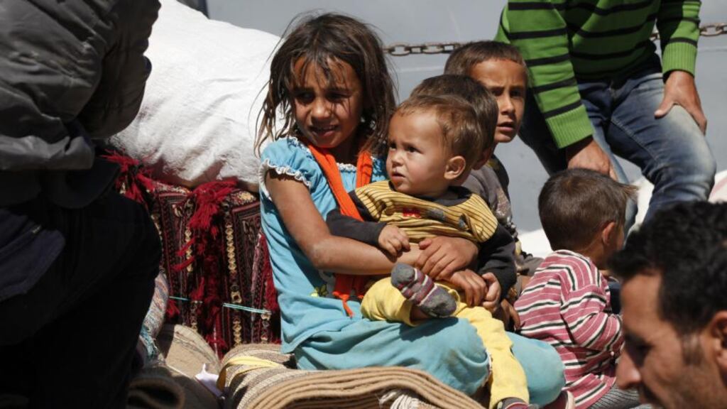 Newly arrived Syrian Kurdish refugees wait with their belongings after crossing into Turkey from the Syrian border town of Kobani. Photograph: Getty Images