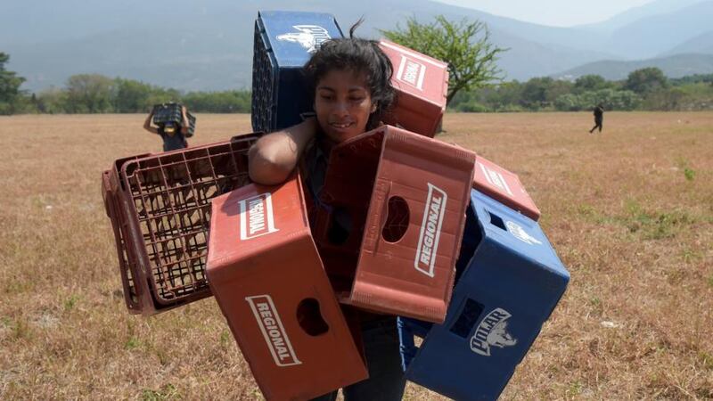 Venezuelan Dayana Pirela carries empty soda and beer crates to sell, after crossing from Venezuela through illegal trails in Villa del Rosario, Norte de Santander, Colombia on February 13th, 2019. Photograph: Raul Arboleda/AFP