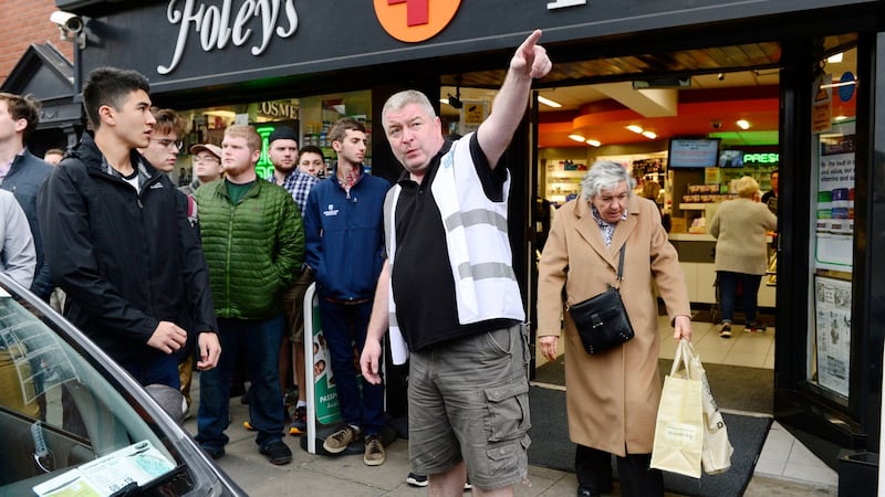 American students on Meath Street with cultural officer for the Liberties James Madigan outside Foleys Chemist. Photograph: Cyril Byrne