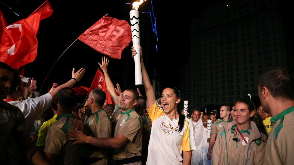 Model Adriana Lima carries the Olympic torch in Maua Square, Rio de Janeiro, Brazil. Photo: Pilar Olivares/Reuters