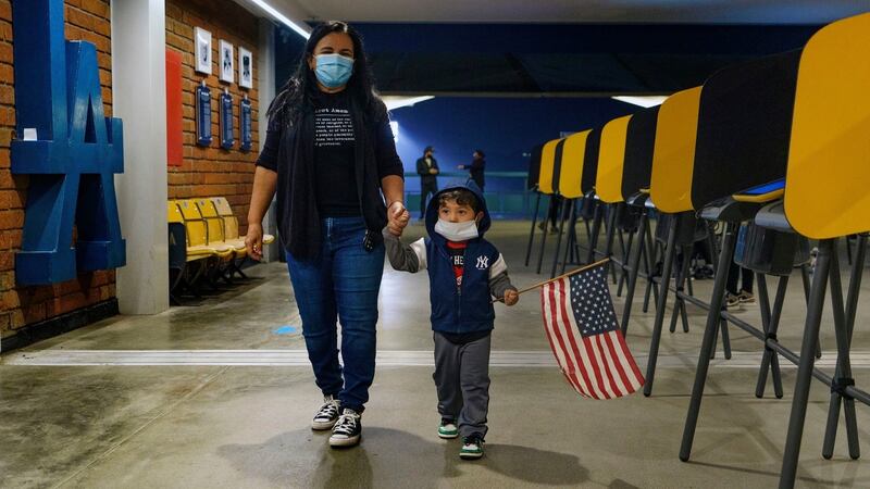 Lisa Carrera holds the hand of her grandson Maverick (2) after casting her ballot at Dodger Stadium, Los Angeles on Monday. Photograph: Damian Dovarganes/AP