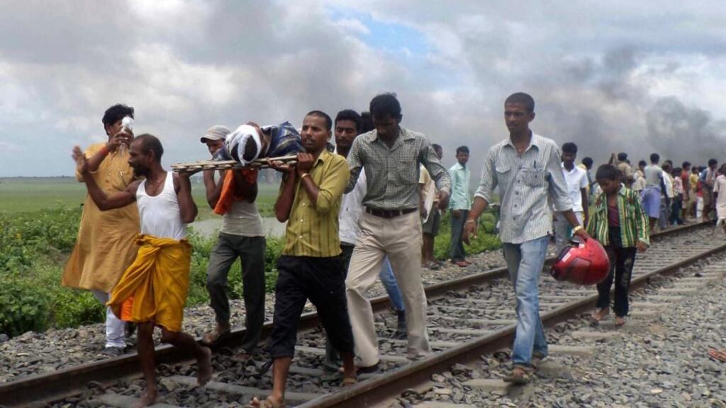 Indian villagers carry an injured person along a rail track after a train ran over a group of Hindu pilgrims at a crowded station in Dhamara Ghat, Bihar state in India yesterday. Photograph: AP Photo