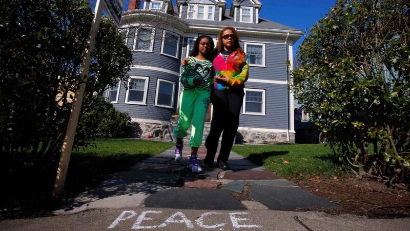 Jacqueline Myers (right) and her ten year-old daughter Amira walk away after leaving a teddy bear on the door step of eight year-old Martin Richard's home in Dorchester. Photograph: Brian Snyder/Reuters
