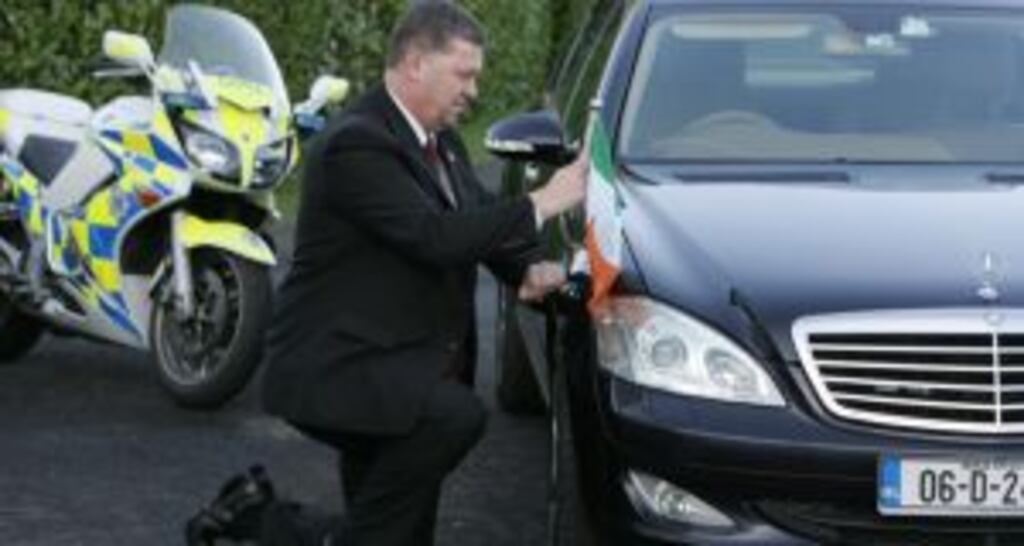 A Garda driver fixing the Tricolour to the presidential car. Photograph: Frank Miller
