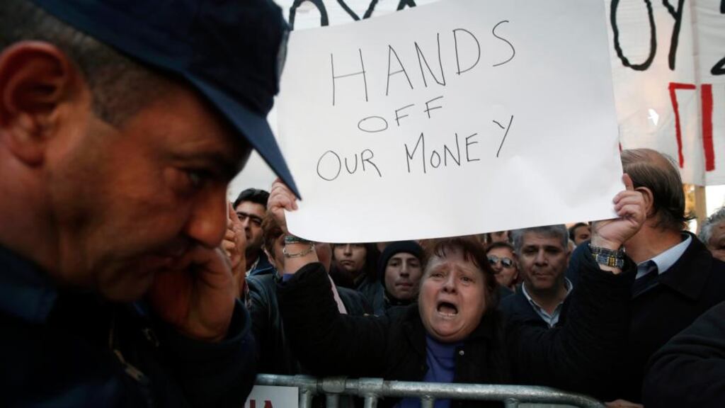 Protesters shout slogans during an anti-bailout rally outside the parliament in Nicosia. Photograph: Reuters