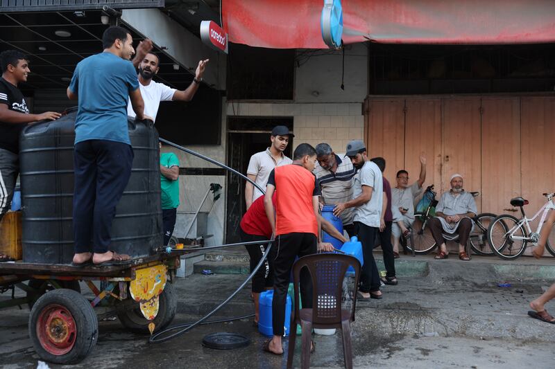People collect water from a mobile cistern in Rafah in the southern Gaza Strip. Photograph:  Mohammed Abed/AFP via Getty Images