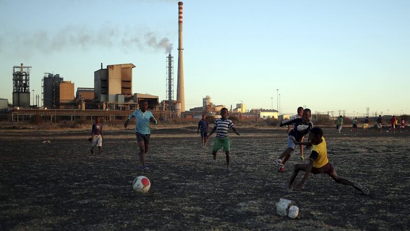 Boys play soccer in Marikana’s Nkaneng township in front of the Lonmin’s Marikana platinum mine in Rustenburg, South Africa: Under the latest revision, black people’s shareholding in mining companies must increase from 26 per cent to 30 per cent within 12 month.   Photograph: Siphiwe Sibeko/Reuters
