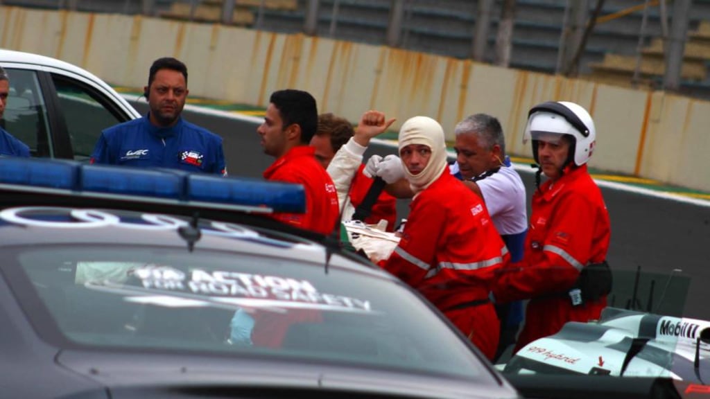 A handout picture shows Australian driver Mark Webber giving a thumbs up as a medical team bring him from the Interlagos track after a crash during the six-hour World Endurance Championship event. Photograph: Gabriel Pedreschi/EPA
