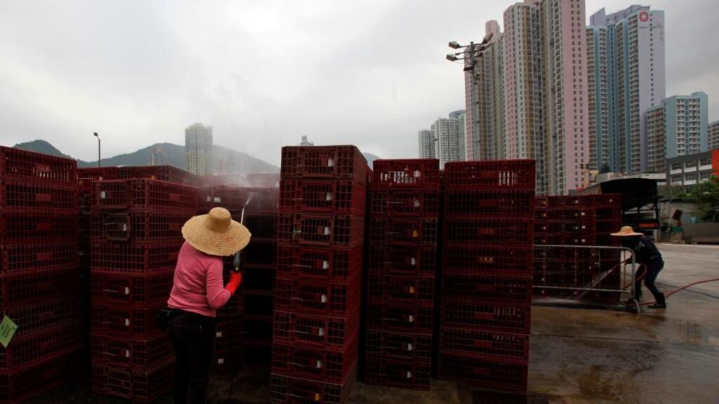 Workers clean empty cages, which were used to transport chickens, after morning trading at a wholesale poultry market in Hong Kong.