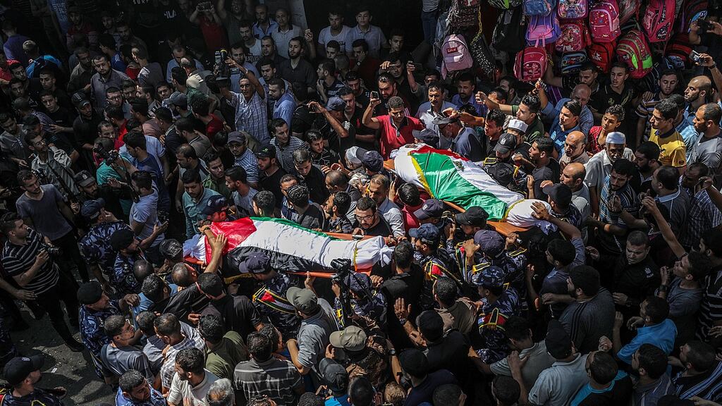 Palestinians carry two bodies of the three Hamas policemen killed in bomb blasts a day earlier during their funeral in al Omari mosque, Gaza City. Photograph: Mohammed Saber/EPA