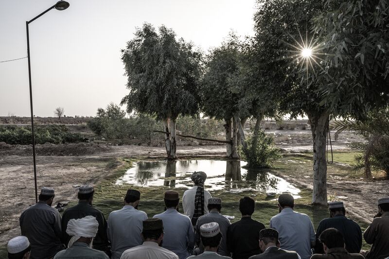 Men pray on a small patch of grass in Shagai, in southwest Afghanistan’s arid Bakwa district, on August 17th, 2023. Photograph: Bryan Denton/The New York Times