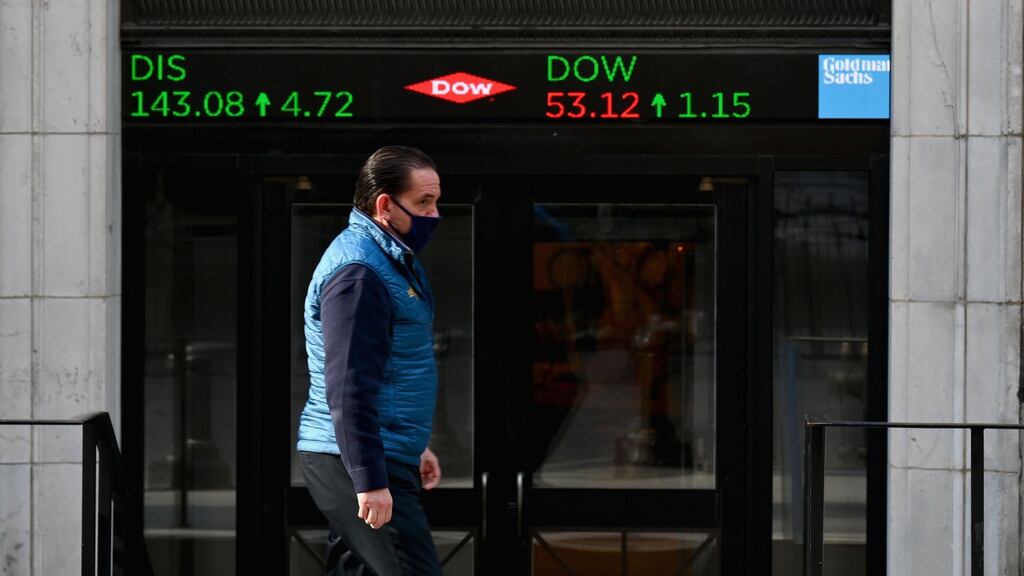 A stock trader walking past the New York Stock Exchange on  Wall Street.  Photograph: Getty Images
