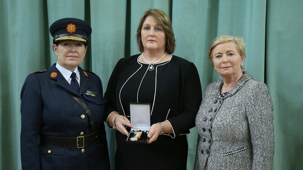 Detective Garda Adrian Donohoe’s widow Caroline (centre) receives a posthumous Scott Medal for bravery from Garda Commissioner Noirin O’Sullivan (left) and Minister for Justice Francis Fitzgerald at a ceremony at Templemore Garda Training College. Photograph: PA