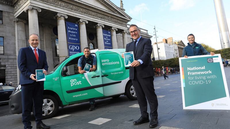 Taoiseach Micheal Martin launching the National Framework for Living with Covid-19 Information Leaflet with An Post CEO David Redmond and employees Laura Fitzsimons and Keith Lally outside the GPO, Dublin. Photograph: Julien Behal Photography/PA Wire
