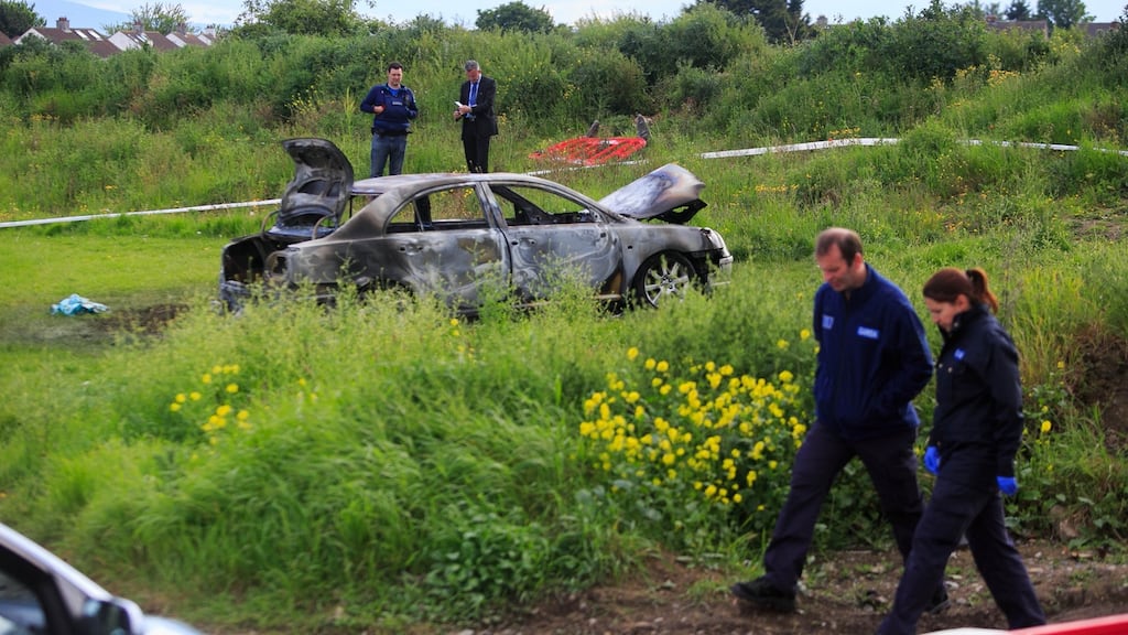 Garda members at the scene of a burned-out car at Castletimon Gardens, Coolock, Dublin, following the shooting dead of Hamid Sanambar. Photograph: Gareth Chaney Collins