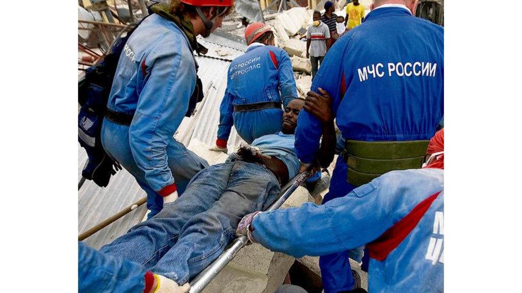 Pierre Louis Ronny is carried away by Russian rescuers after being found under the Teleco Haitian telecom building in Port-au-Prince yesterday. Mr Ronny spent the past week without food or water with his hand trapped between cement blocks and was found by looters who were combing the building for goods. Photograph: Logan Abassi/Reuters/UN