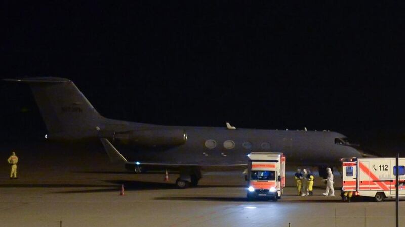 An ebola-infected patient is helped as he walks in between two ambulance cars after arriving with a German Air Force plane from Western Africa, at the airport Halle/Leipzig, in Schkeuditz, Germany, this morning. Photograph: Peter Endig/Reuters