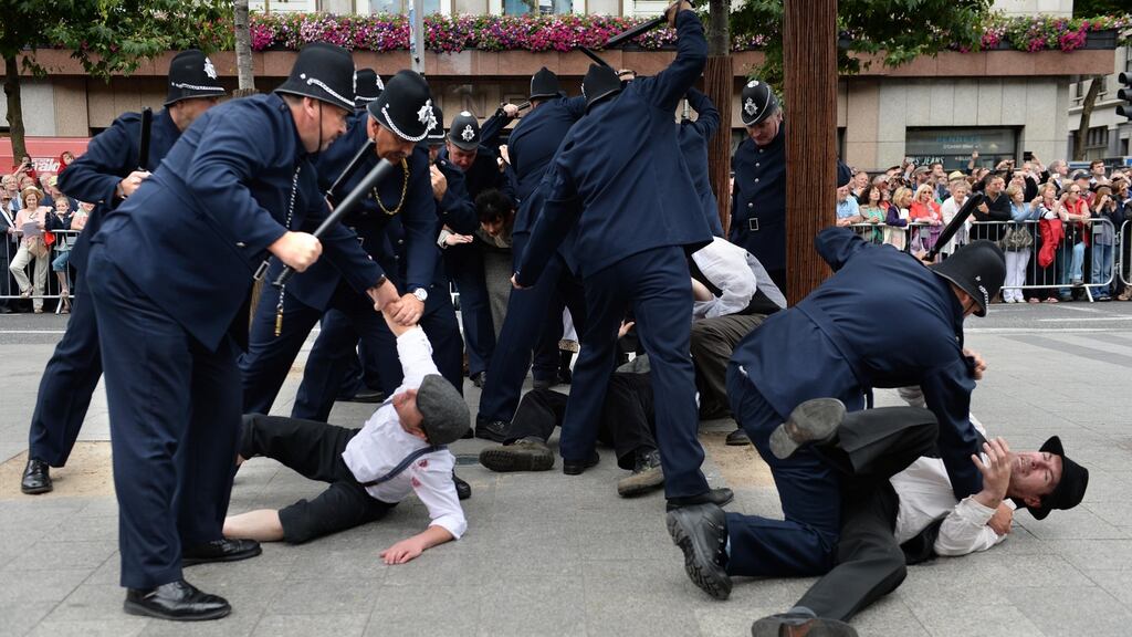 Recreating the DMP baton charge of dockers and Jacob’s workers at the State commemoration of the 1913 Lockout and community event on O’Connell Street, Dublin in August 2013. Photograph: Dara Mac Dónaill