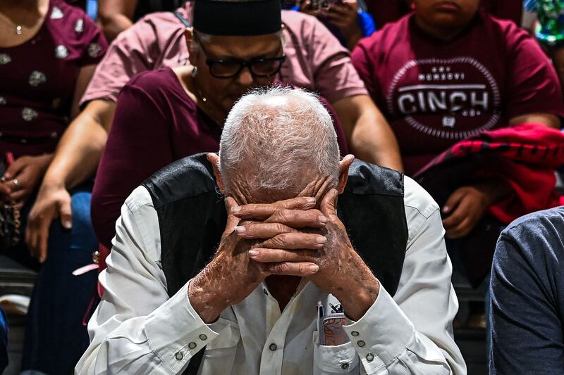 People from the community gather as they mourn during a vigil for the victims of the mass shooting at Robb Elementary School.